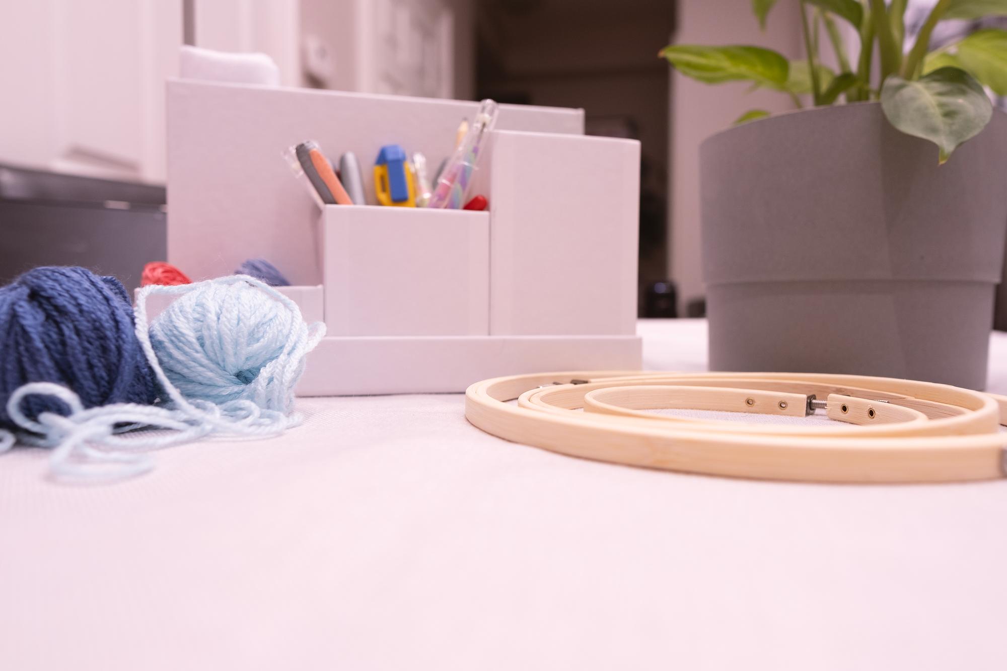 Studio table with threads, needles and embroidery hoop
